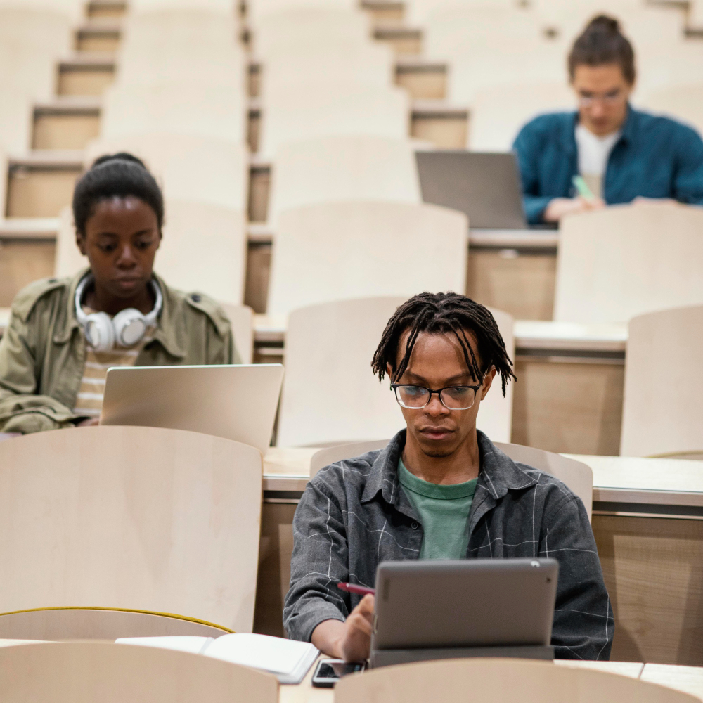 Confident student working on a laptop in a modern library